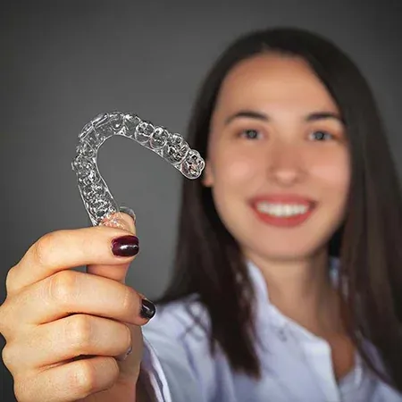 Paciente mostrando su alineador de ortodoncia invisible